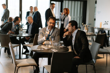 Zwei Männer sitzen an einem Tisch und sprechen miteinander